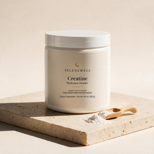 Selenewell Creatine Hydration Powder tub on travertine stone with a wooden scoop